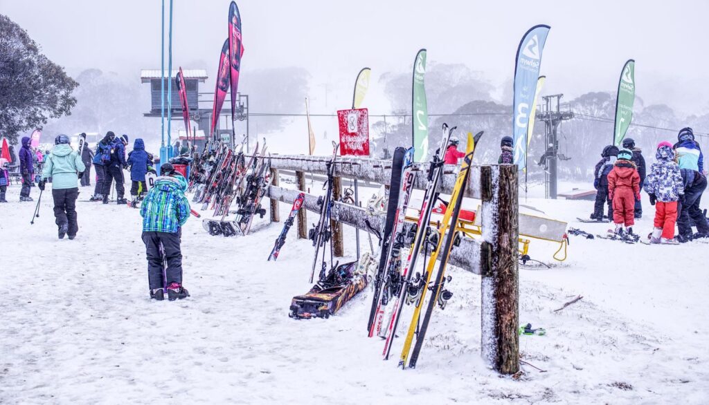 Snowy ski resort scene with people and ski equipment ready for winter activities.